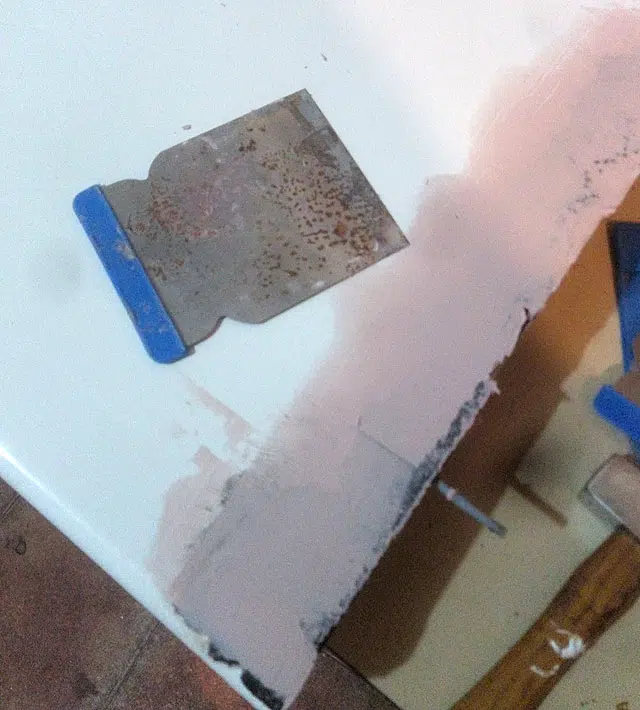 Application de mastic de carrossier pour boucher les trous