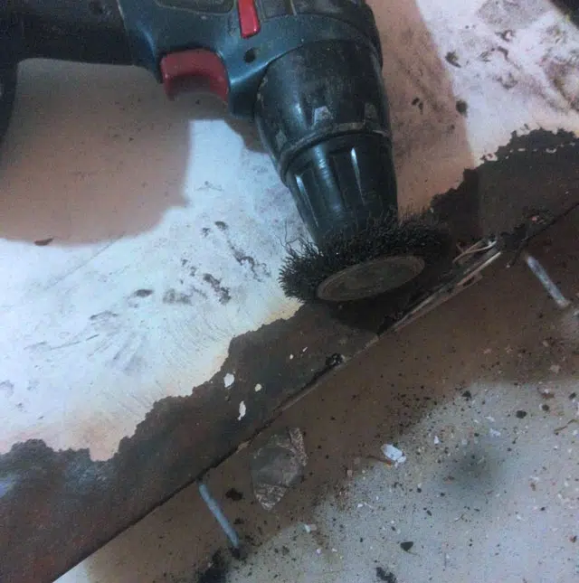 Étape de ponçage de la rouille sur un couvercle de lave-linge